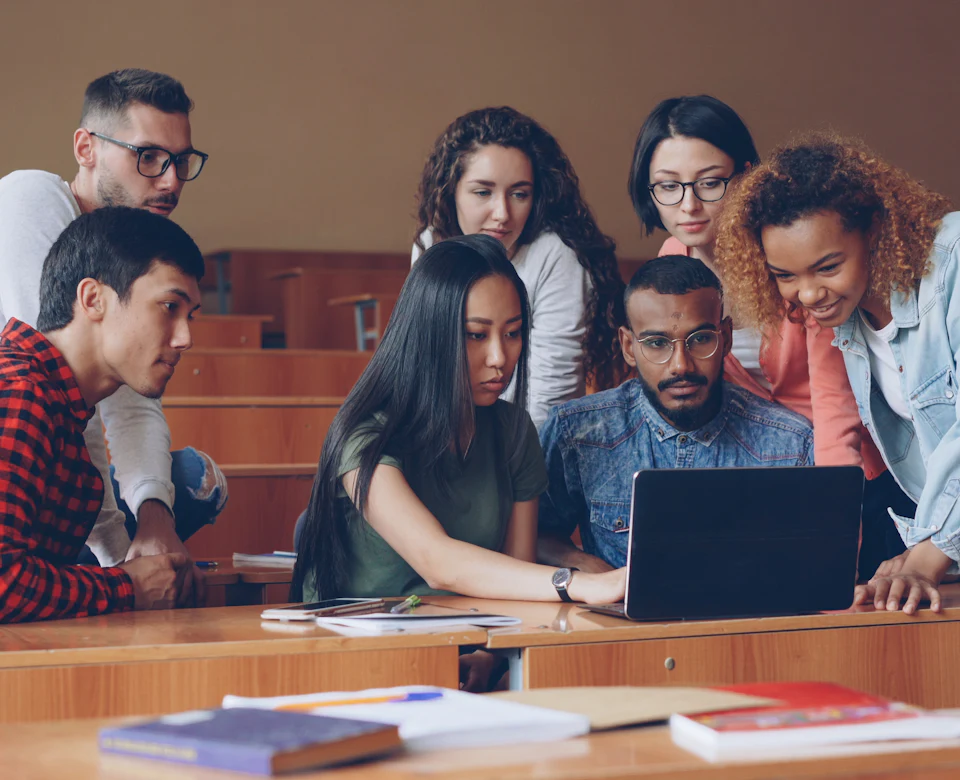 University students collaborating around a laptop
