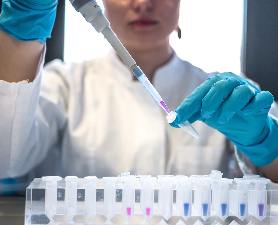 Lab scientist pipetting patient samples into test tubes