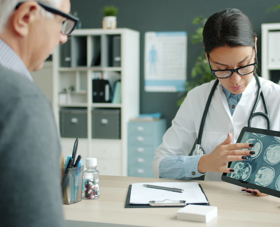 Doctor showing a patient scan results on a tablet in a clinic