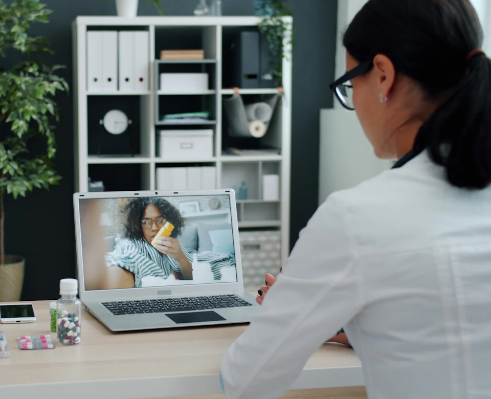 Doctor consulting a patient over a video call on a laptop